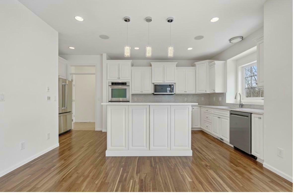 Highland Hills kitchen after — white cabinetry, quartz island, pendant lights