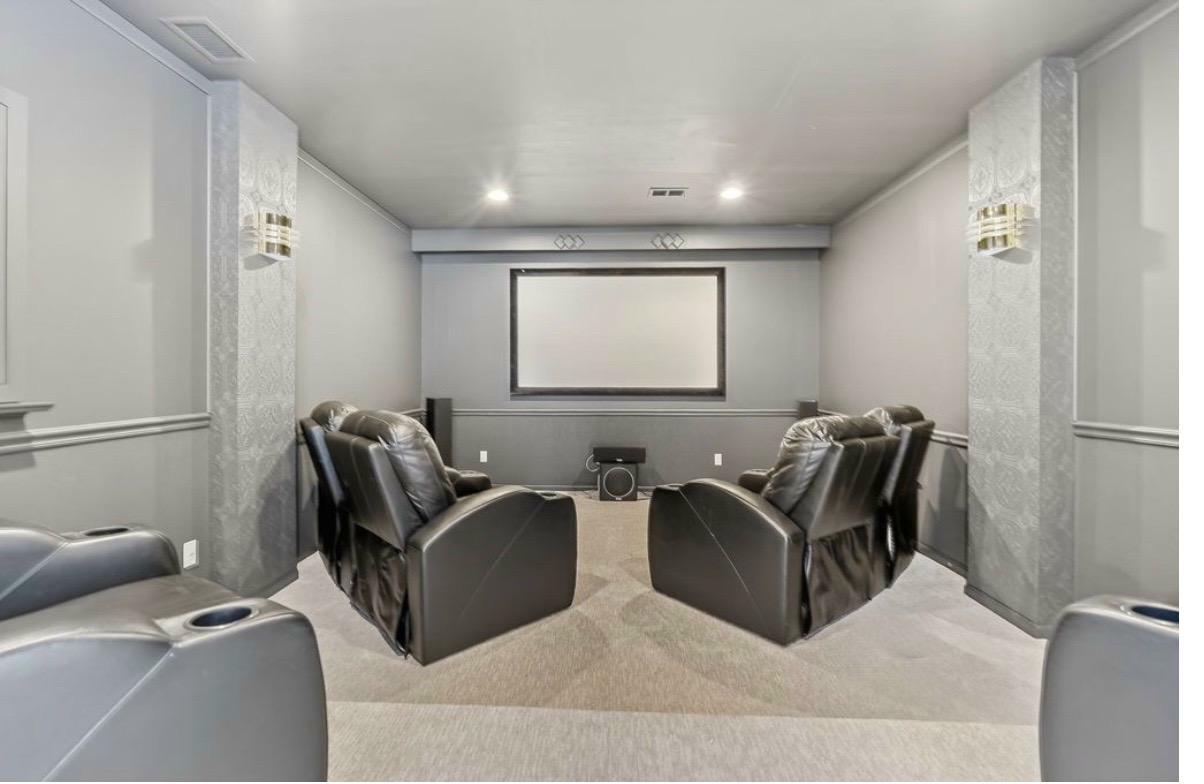 Highland Hills home theatre after — projector screen, recliners, sconces, carpet