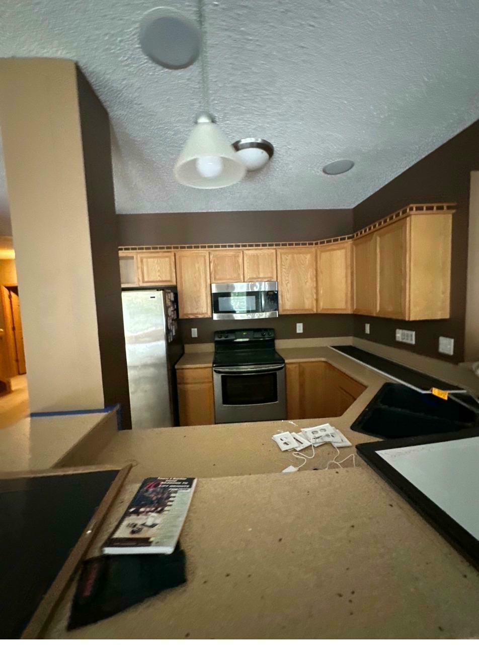 Basement kitchen before — dated oak cabinets, brown walls