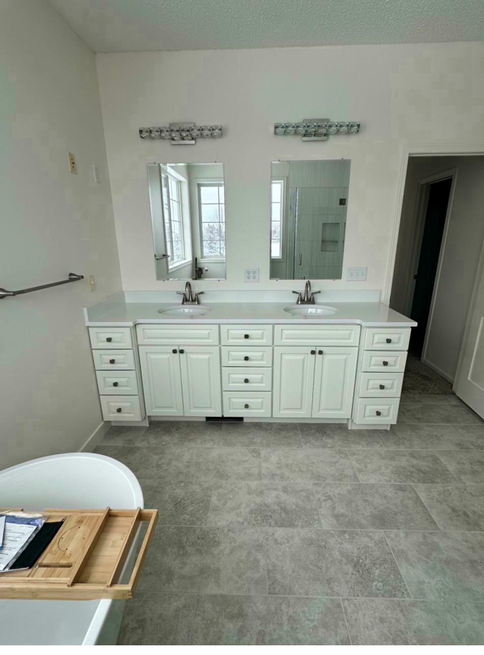 Primary bath after — double vanity, quartz countertop
