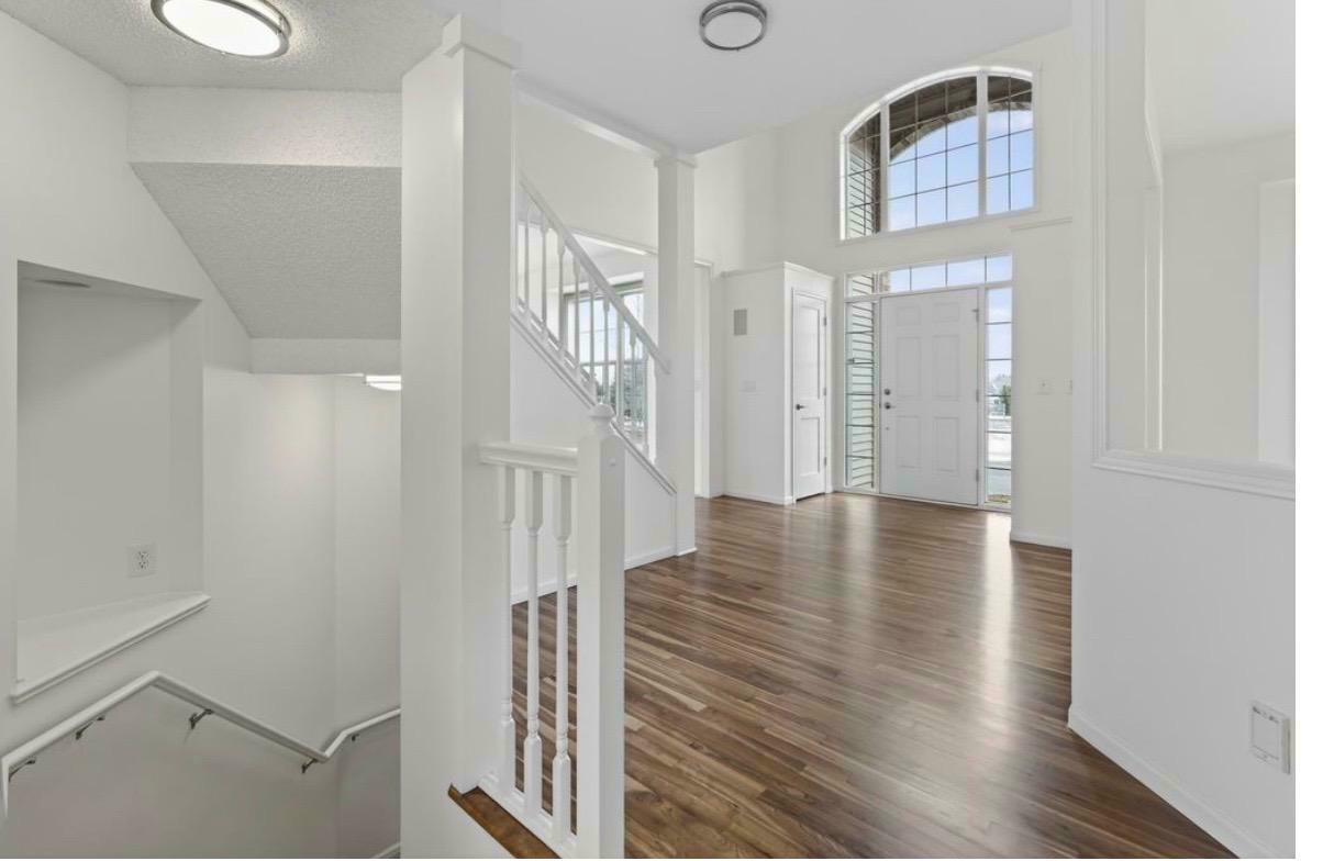 Foyer — two-story entry, hardwood floors, painted staircase