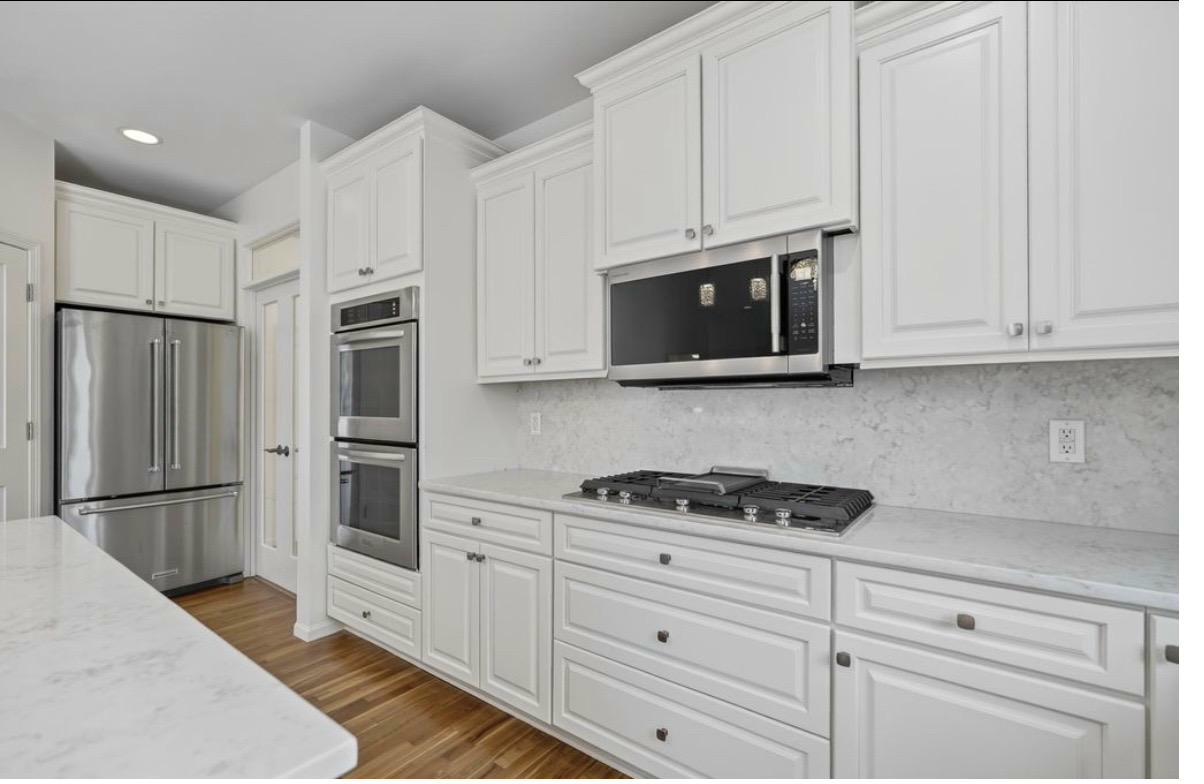 Kitchen — double wall ovens, gas cooktop, marble backsplash, quartz counters