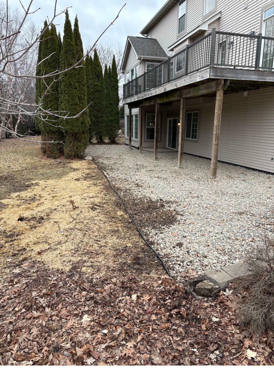 Rear patio after — river rock, class 5 base, landscape edge