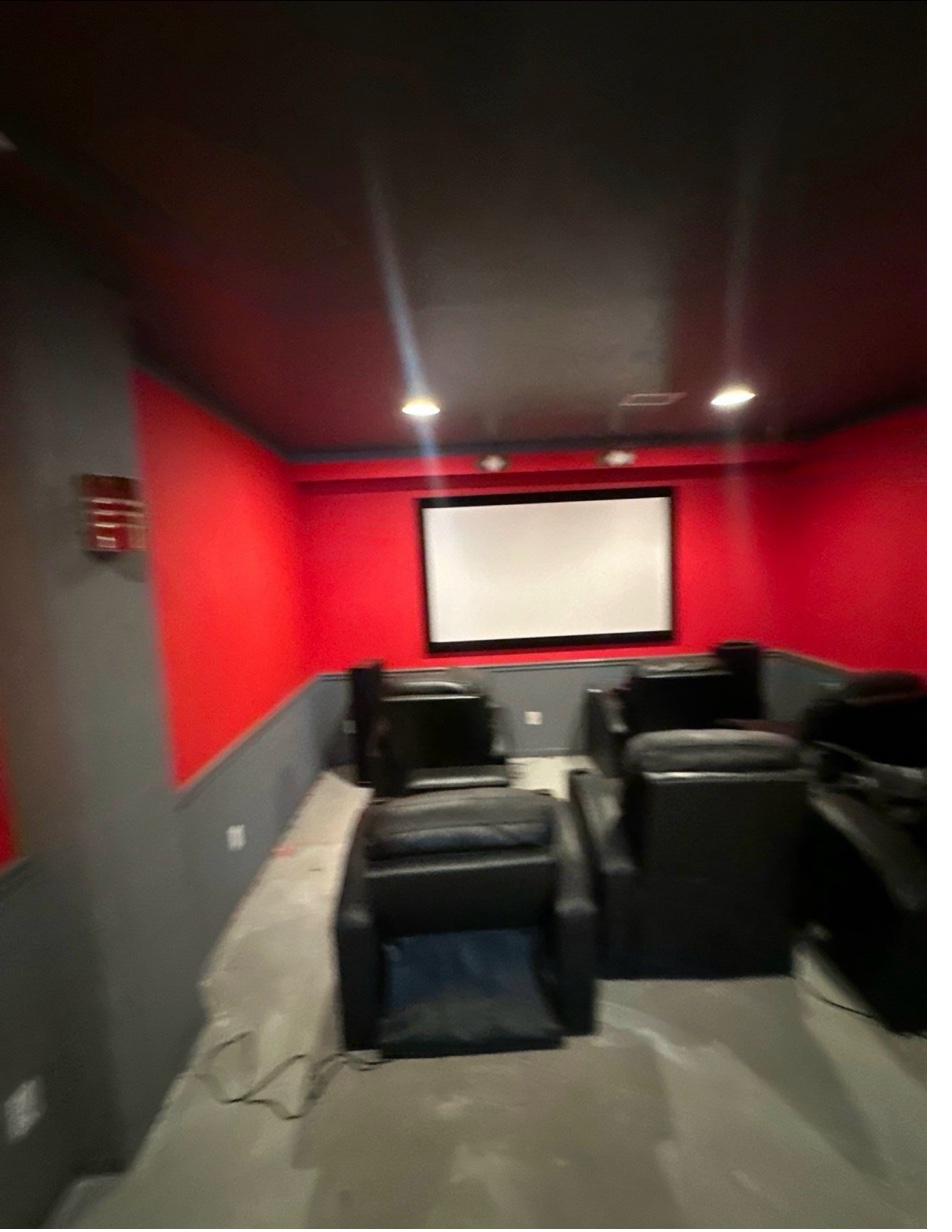 Highland Hills home theatre before — red walls, gray wainscot, bare concrete floor