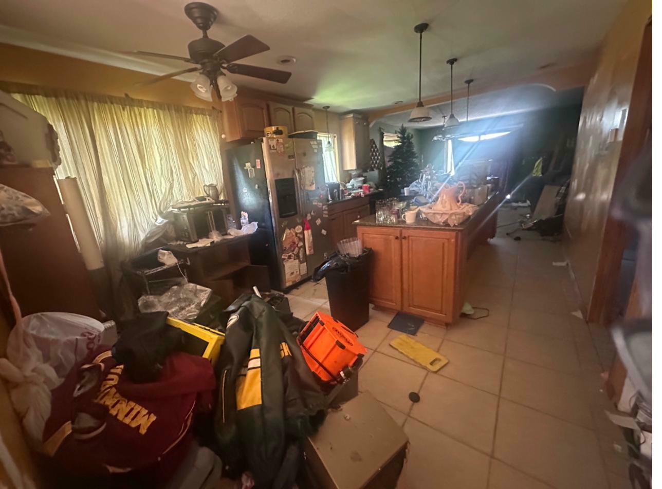 Kitchen before — old oak cabinetry, dated tile, cluttered