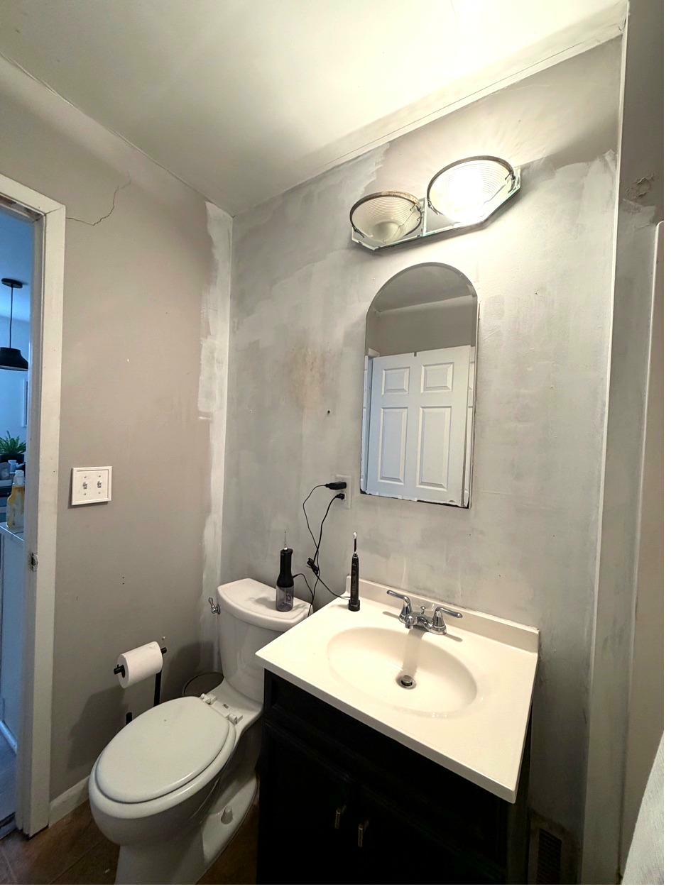 NE Minneapolis bath before — vanity angle, dated fixtures, bare walls